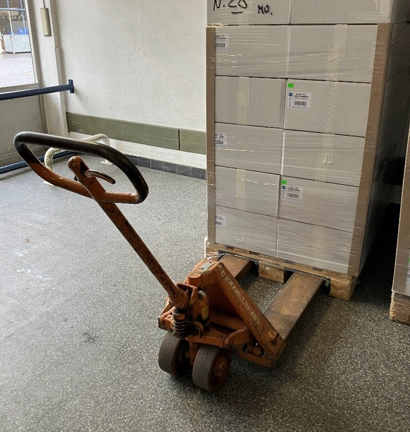 Handhubwagen beladene Palette in einem Lagerraum.